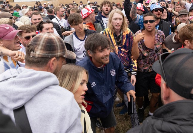 30/06/24 Pictured: Caption: Louis Tomlinson watches the England Game at Glastonbury. The football was not shown at the festival but some festival-goers set a a make shift screen to live stream the game festival-goers at Glastonbury festival today for the Glastonbury Music Festival that takes place Friday, Saturday and Sunday on Worthy farm, Somerset