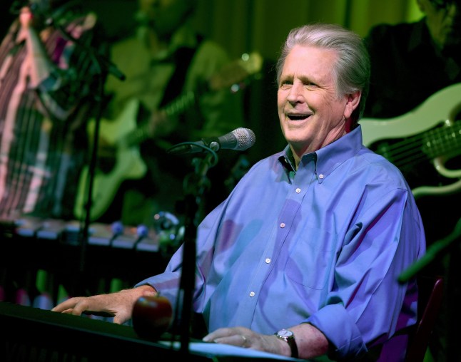Musician Brian Wilson performs in a blue shirt.