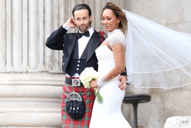Melanie Brown and Rory McPhee in wedding attire standing with their arms around each other