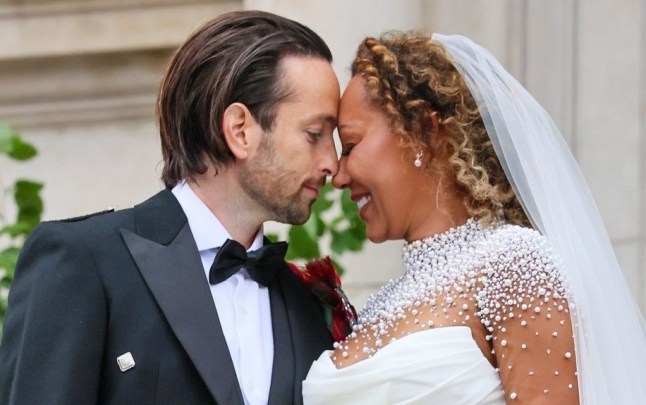 Melanie Brown and Rory McPhee in wedding attire resting their heads together