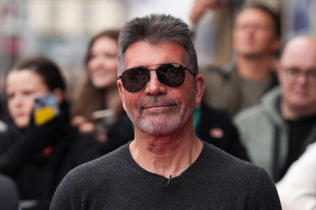 Simon Cowell in sunglasses and black top.