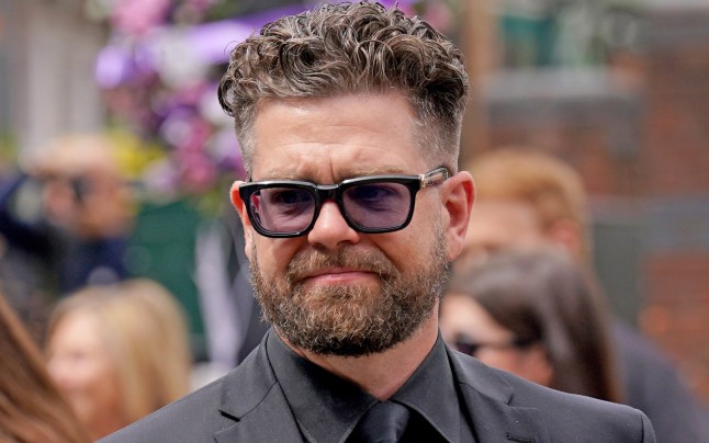 Jack Osbourne views the messages and floral tributes left at the Black Sabbath Bridge bench on Broad Street in Birmingham in memory of Black Sabbath frontman Ozzy Osbourne, as his body is brought back to his home city for a procession following his death last week aged 76. Picture date: Wednesday July 30, 2025. PA Photo. Photo credit should read: Joe Giddens/PA Wire